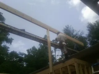 Carpenter setting a ridge beam over a new addition frame — Ice Dam Removal by Roofing Brothers in Royal Oak