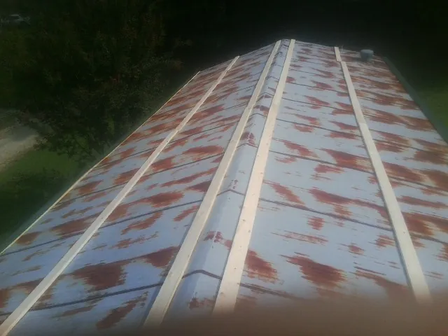 Rusted metal roof panels with new wood purlins before replacement — Storm Damage Roof Repair in Royal Oak by Roofing Brothers