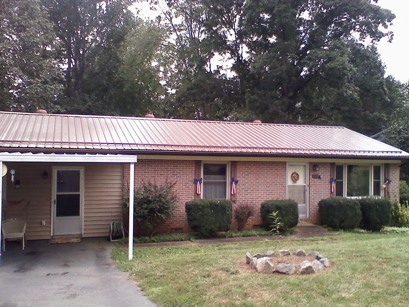 Bronze metal roof and carport on a brick ranch home — Roof Repair work by our crew in Royal Oak