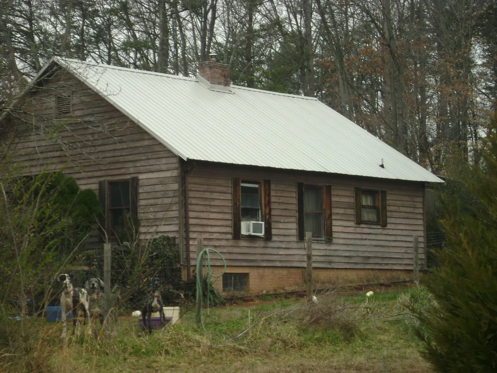 White metal roof on an old wood sided farmhouse, from a Metal Roof Installation job in Royal Oak